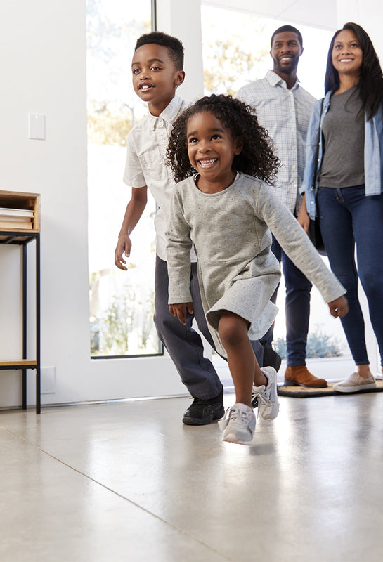 Family walking into home after using LiO Hand Sanitizing System